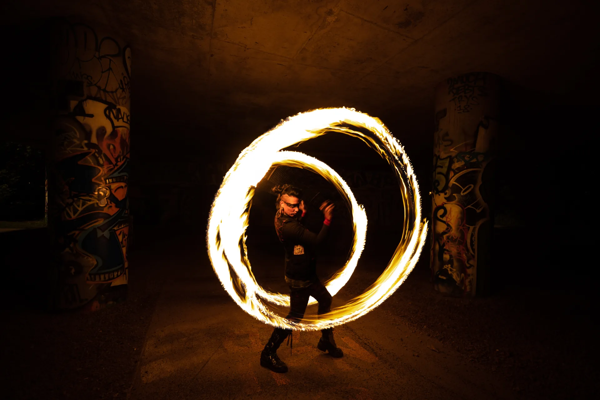 Artiste de feu traçant un cercle de flammes lors d'une performance nocturne